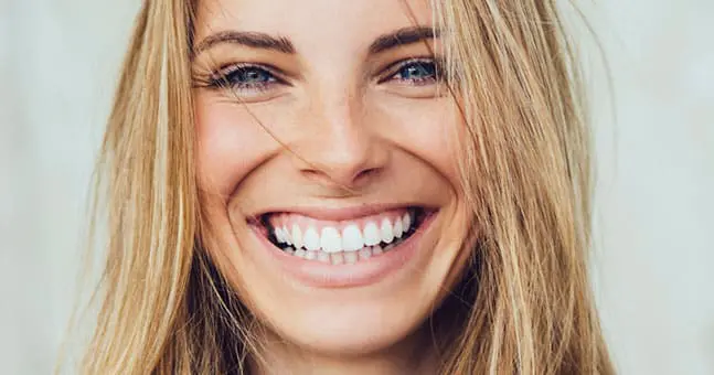 Closeup of woman smiling with white teeth.