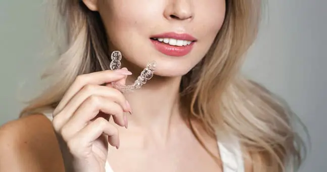 Woman Holding Dental Braces near Harrison Township MI