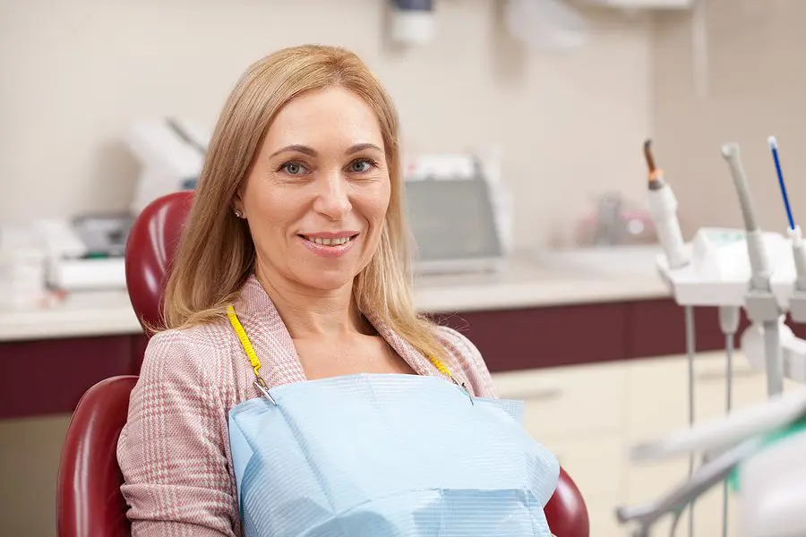 Senior Lady Sitting In A Dental Chair At The Clinic, Waiting For