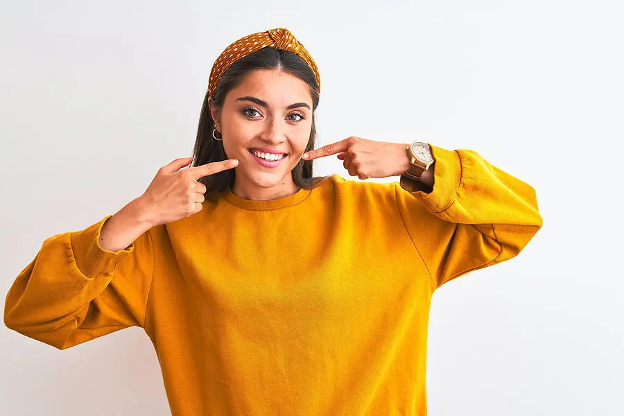 Young beautiful woman wearing yellow sweater and diadem over iso