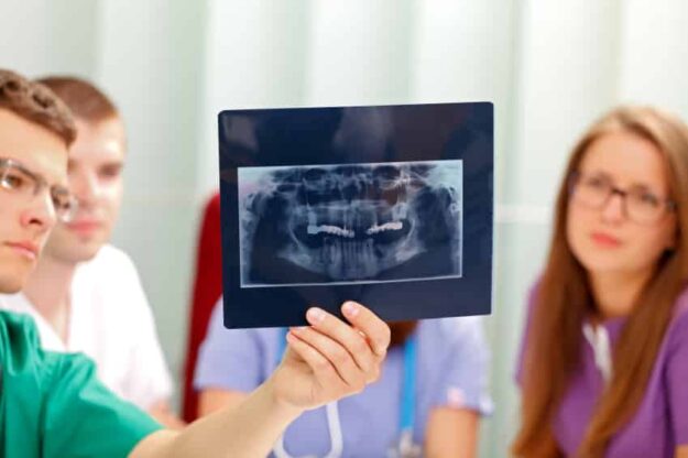 Dentists Holding X-rays For Patient To See Dentists Holding X-rays For Patient To See