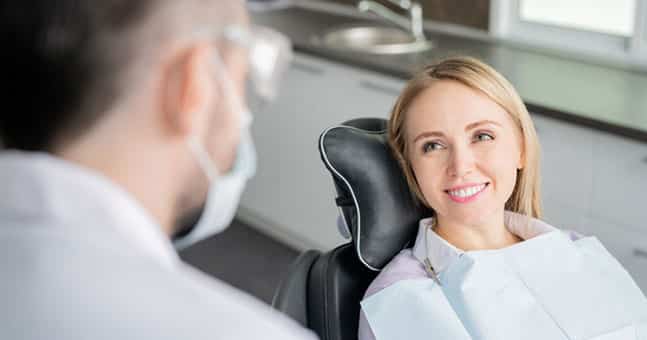 Girl in dental chair receiving dental whitening treatment in office near New Haven MI.